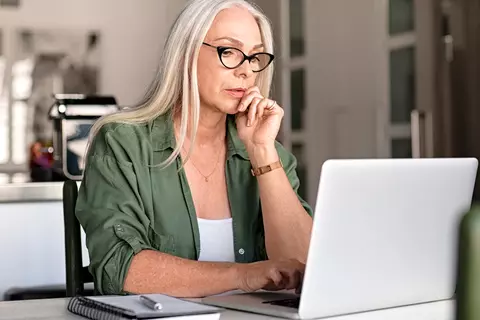 Frau sitzt vor dem Laptop und macht einen Verdauungsprobleme Test