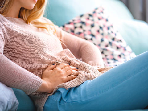 Frau mit Verdauungsproblemen hält sich den Bauch