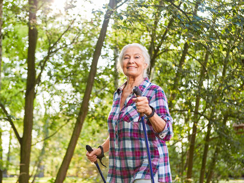 Ältere Dame beim Nordic Walking