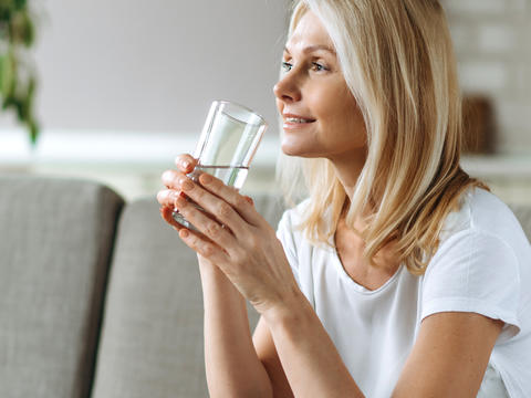 Eine Frau trinkt Wasser aus einem Glas