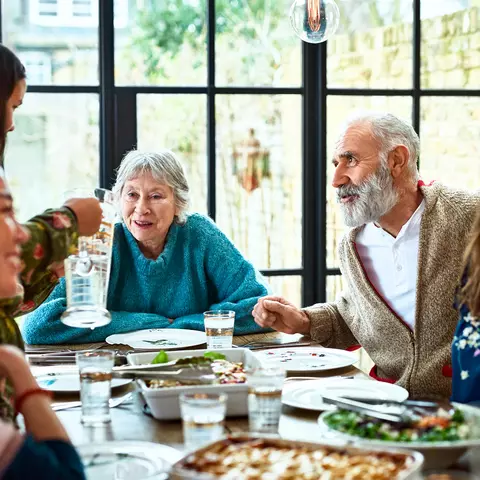 Eine Familie unterhält sich gut gelaunt beim Essen